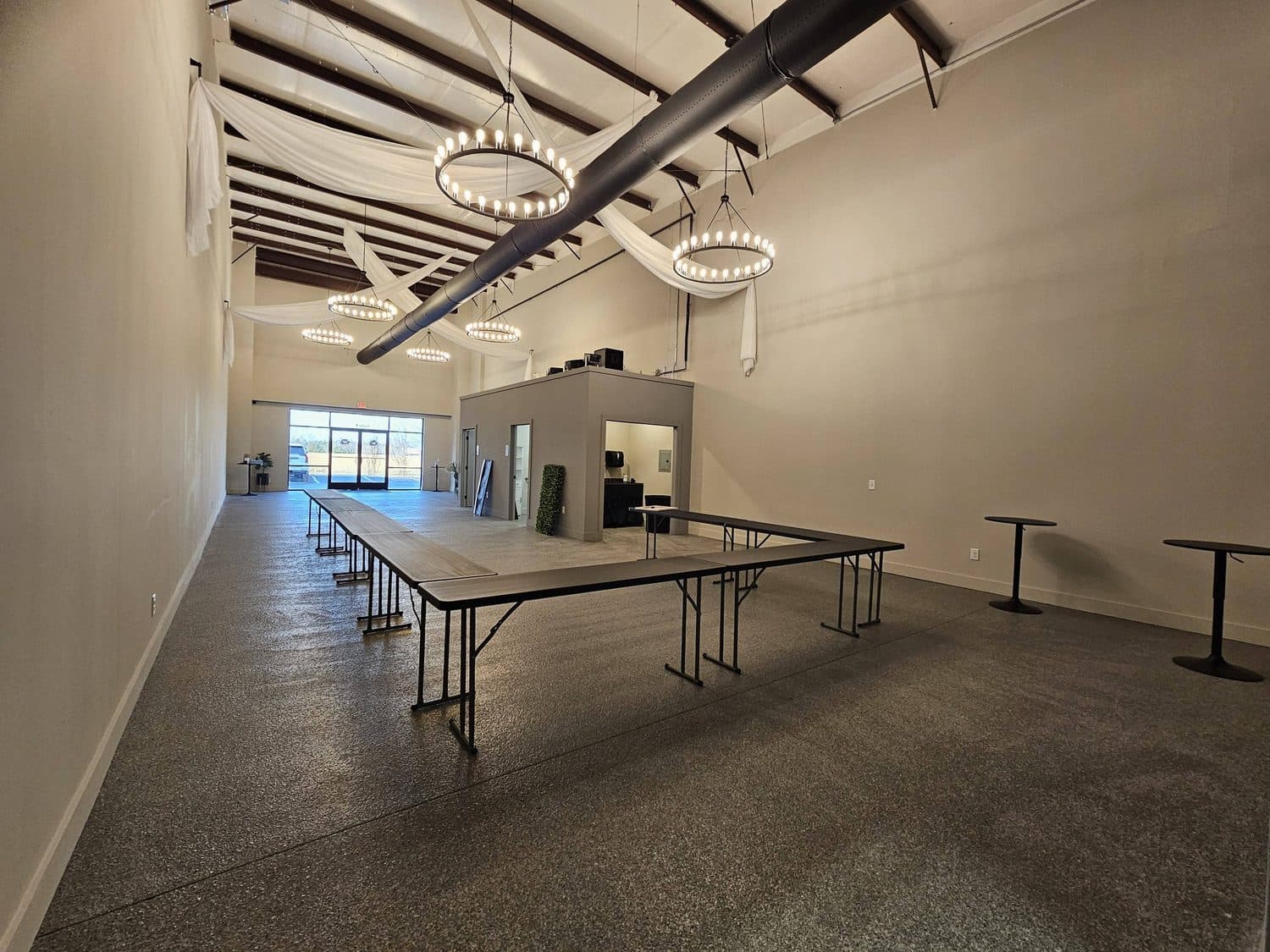 The room seen down its length, showing the depth of the floor and the black exposed ceiling