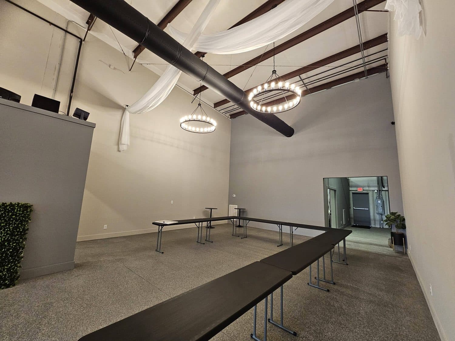 A long run of tables down the middle of the room under circular ring pendant lights